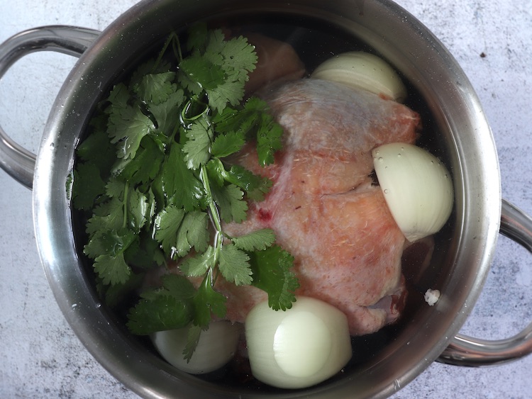 Pato temperado com sal, cebola e coentros num tacho