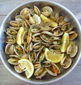 Steamed clams with lemon and garlic on a large skillet