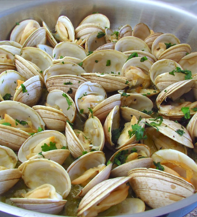 Steamed clams with lemon and garlic on a large skillet