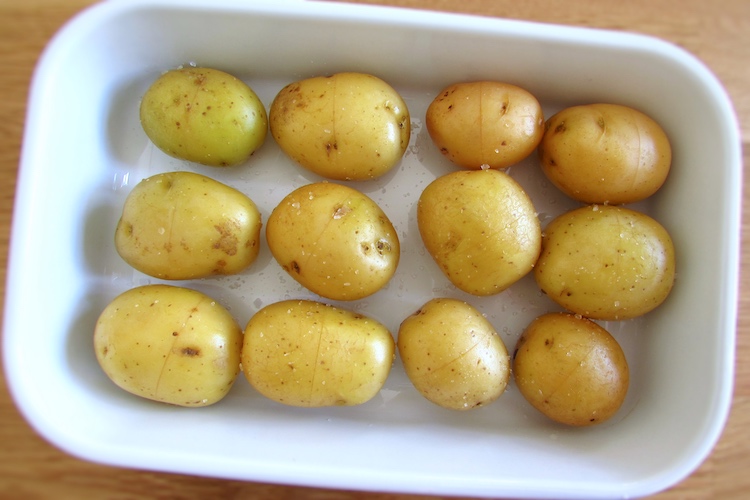 Potatoes seasoned with salt on a baking dish