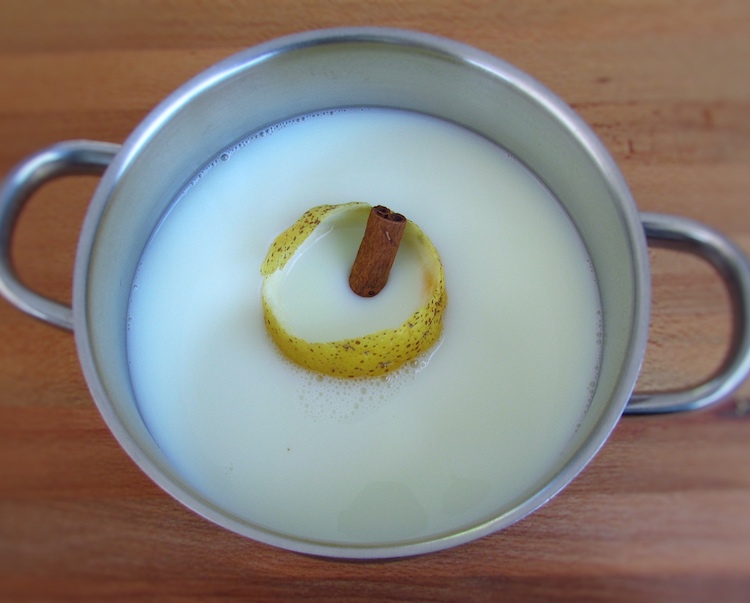 Milk, lemon peel and cinnamon stick on a saucepan