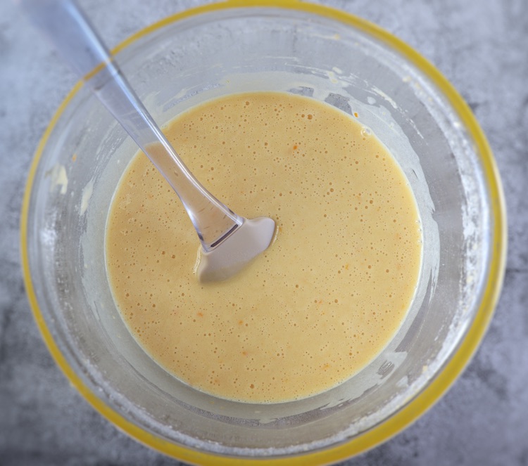 Orange cake dough on a glass bowl