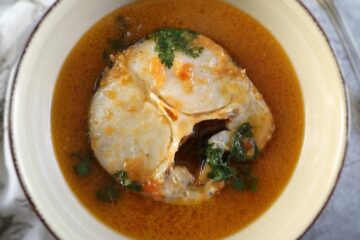 Peixe em molho de tomate num prato fundo