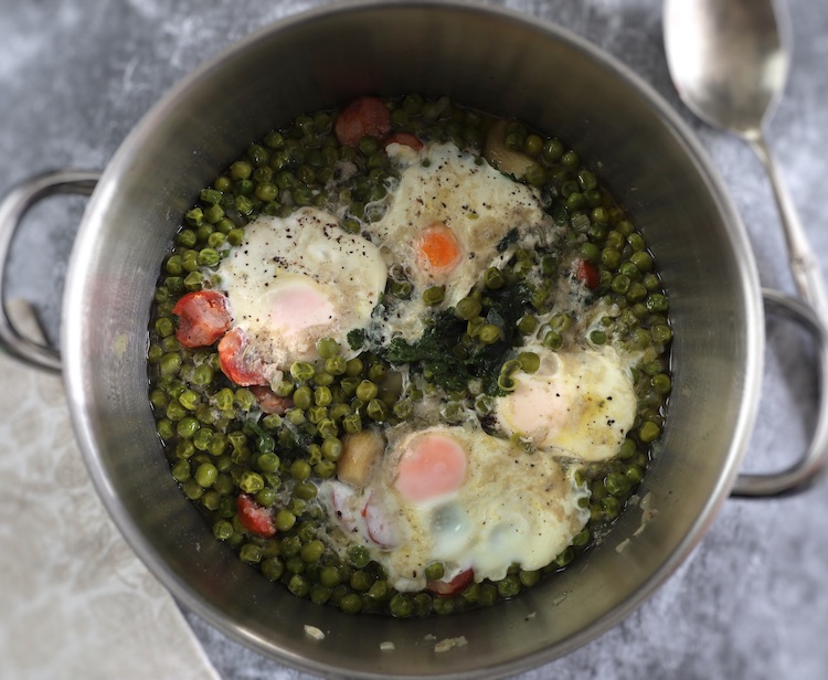 Portuguese peas with poached eggs and chouriço in a large saucepan