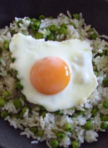 Rice and peas with poached eggs on a dish bowl