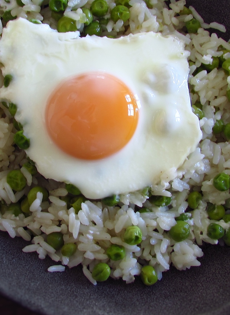 Rice and peas with poached eggs on a dish bowl