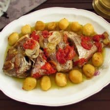 Roast fish with potatoes on a platter