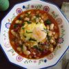 White beans with chouriço and poached egg on a dish bowl