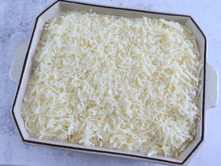 Bacalhau com batatas, natas e queijo ralado numa assadeira