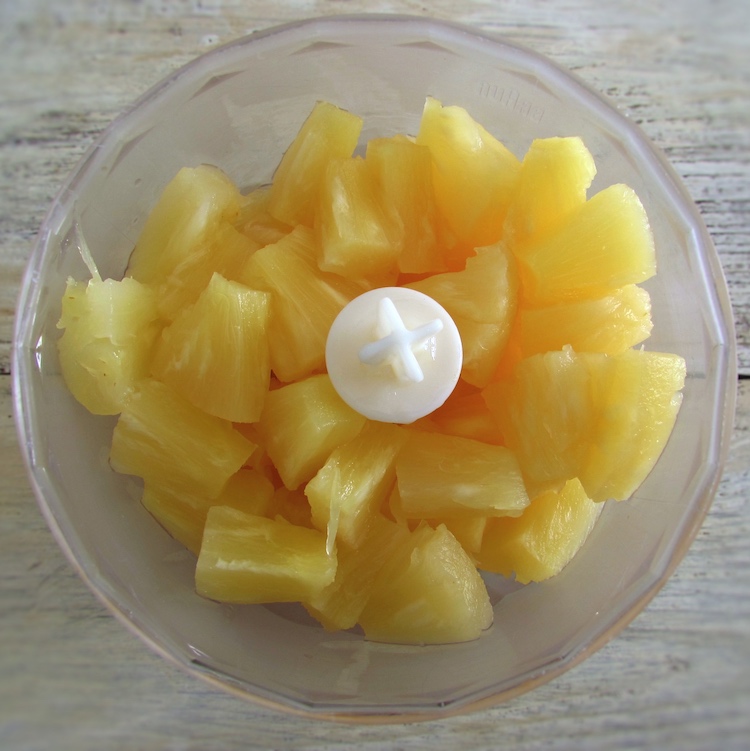 Pineapple cut into pieces in a blender