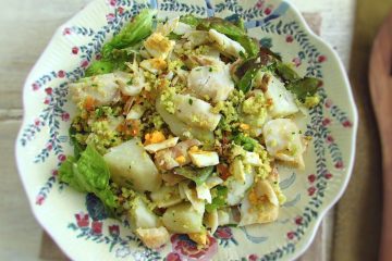Salada de bacalhau com broa de milho num prato