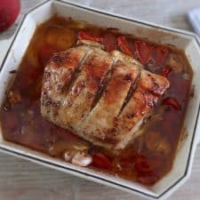 Roasted pork loin with tomato and onion on a baking dish