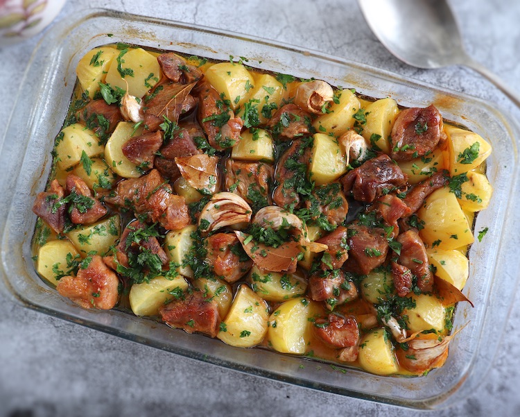 Baked pork with potatoes on a glass baking dish