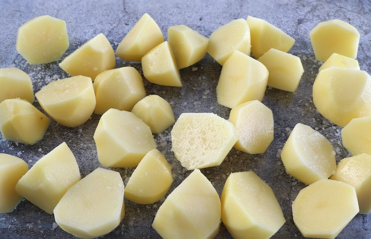 Small potatoes cut in half on a glass baking dish