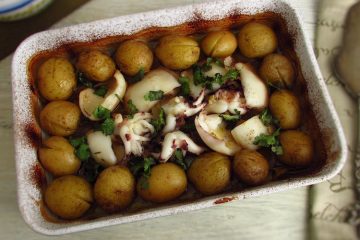Baked cuttlefish with potatoes on a baking dish