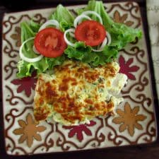 Fish fillets au gratin in the oven with salad on a plate