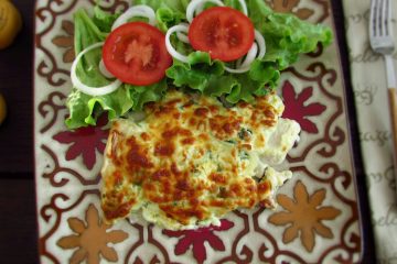 Fish fillets au gratin in the oven with salad on a plate