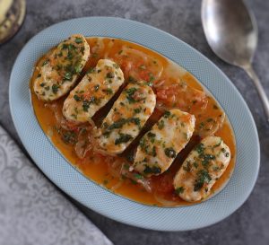 Hake with tomato and coriander on a platter