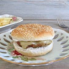 Hambúrgueres simples num prato com pão e queijo