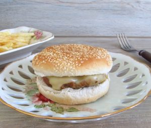 Hambúrgueres simples num prato com pão e queijo