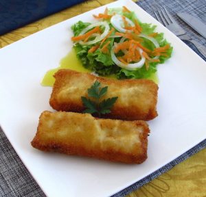 Lombos de pescada panados com salada num prato