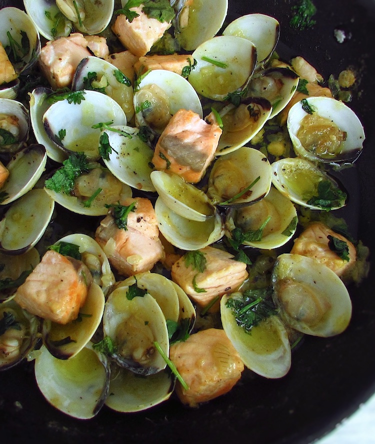 Salmon with clams on a frying pan