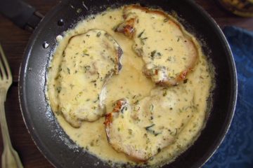 Pork chops with béchamel sauce on a frying pan