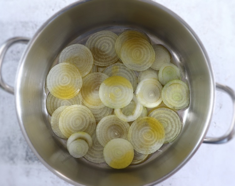 Olive oil and sliced onions on a large saucepan