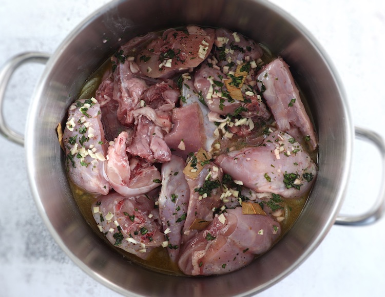 Rabbit cut into pieces seasoned with delicious spices on a large saucepan