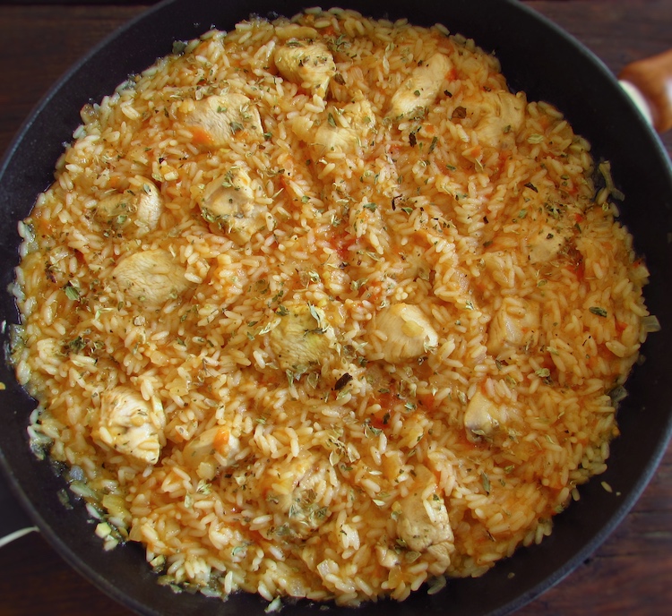 Fried chicken breast with tomato rice on a frying pan