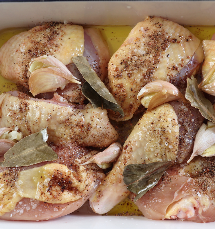 Chicken pieces seasoned with salt, nutmeg, garlic, white wine, bay leaf, olive oil and pepper in a baking dish