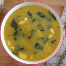 Spinach soup with elbow pasta on a soup bowl