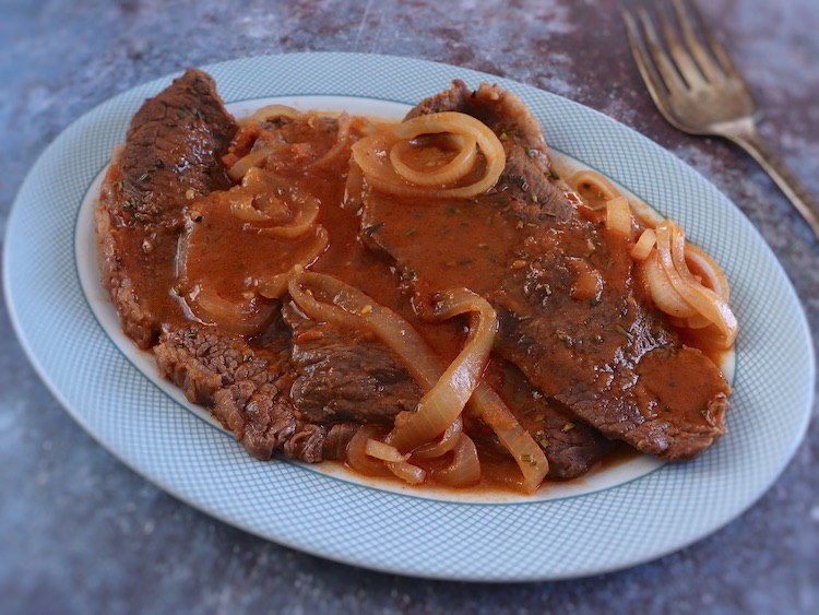 Steaks in tomato sauce on a platter