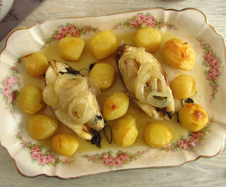 Snapper with potatoes in the oven on a platter
