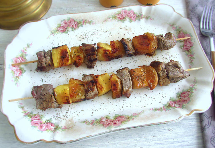 Veal kebabs with pineapple and orange on a platter