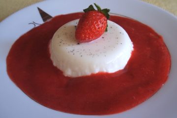 White chocolate panna cotta with strawberry sauce on a plate