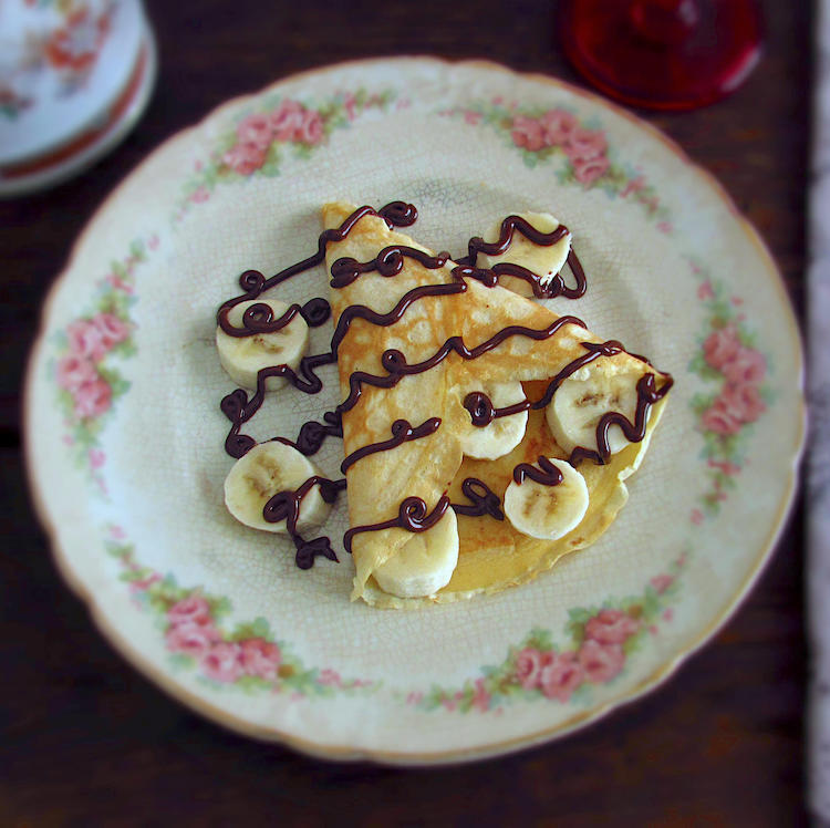 Crepe with banana and chocolate on a plate