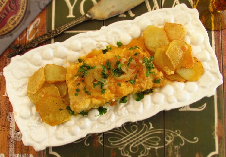 Fried cod with tomato sauce on a platter