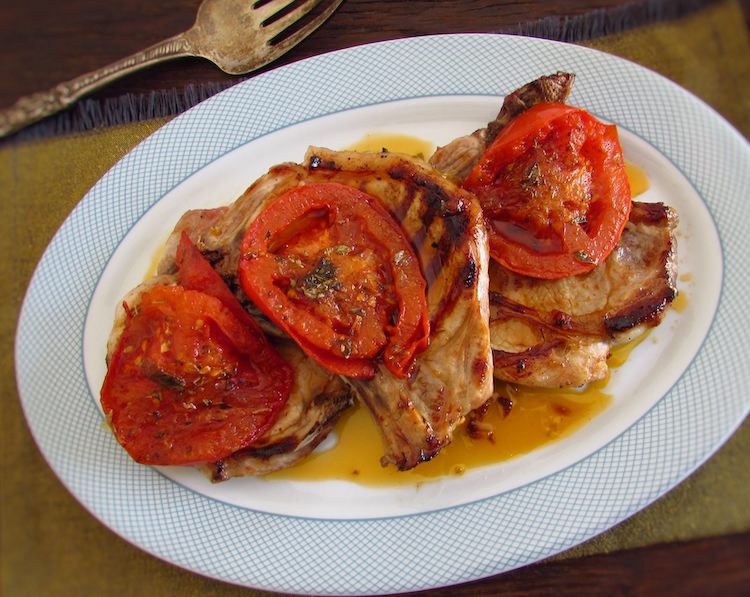 Pork chops grilled with tomato on a platter