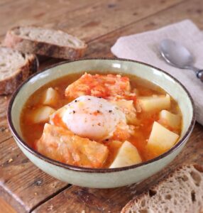 Sopa de Bacalhau com Ovos Escalfados numa tigela de sopa