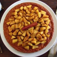Vanilla cake topped with caramelized apple on a plate
