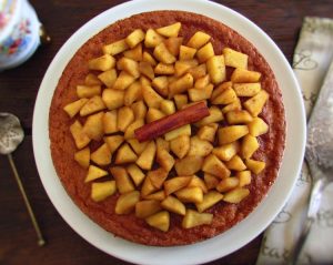 Vanilla cake topped with caramelized apple on a plate