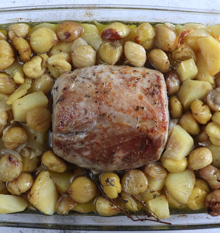Baked pork loin with chestnuts on a glass baking dish