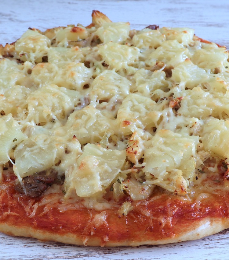Chicken and pineapple pizza on a table