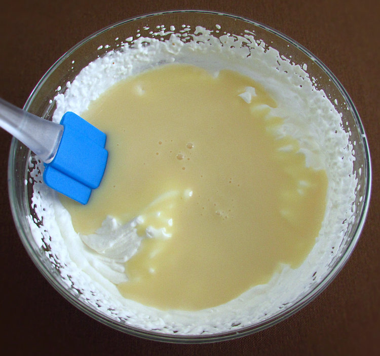 Whipped cream and condensed milk on a glass bowl