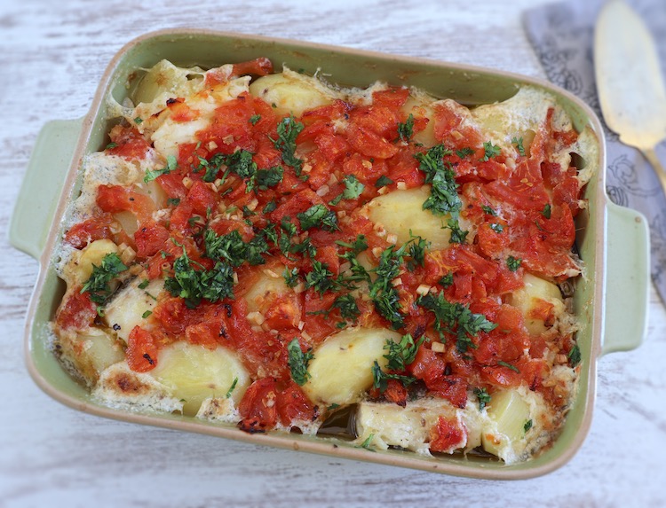 Cod with onion and tomato in the oven on a baking dish