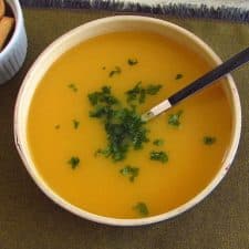 Creamy carrot soup with orange on a soup bowl