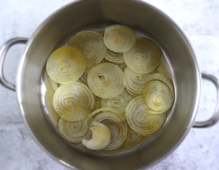 Olive oil and sliced onion on a large saucepan