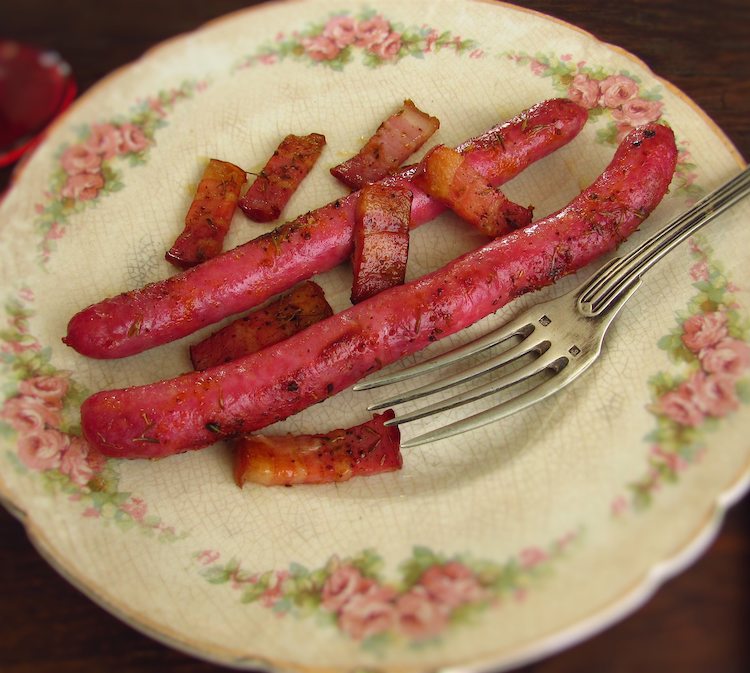 Fresh sausages in the oven on a plate