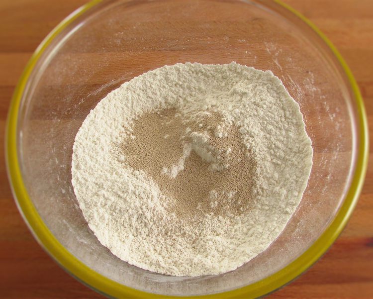 Mixed flour and salt with baker's yeast on a glass bowl